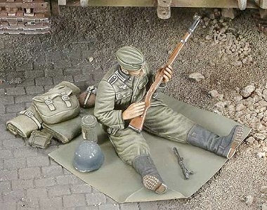 Deutscher Wehrmachtssoldat beim Waffen reinigen
