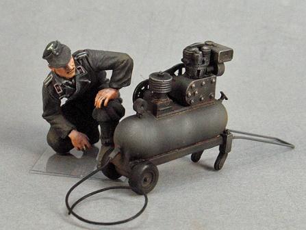 Deutscher Panzersoldat mit Kompressor bei Fahrzeug tarnen